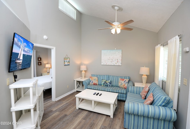 living room featuring dark hardwood / wood-style floors, high vaulted ceiling, and ceiling fan