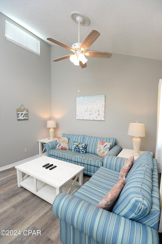 living room featuring hardwood / wood-style floors, a textured ceiling, vaulted ceiling, and ceiling fan