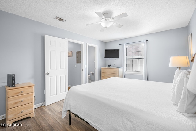 bedroom with ceiling fan, hardwood / wood-style flooring, ensuite bathroom, and a textured ceiling