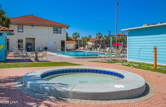 view of pool with a patio area and a community hot tub