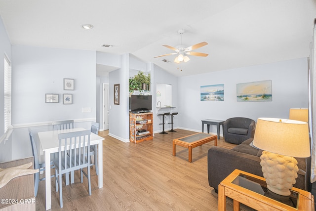 living room with light wood-type flooring, ceiling fan, and lofted ceiling