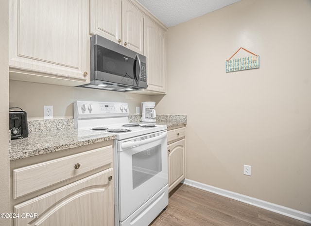 kitchen with light brown cabinets, light stone countertops, a textured ceiling, dark wood-type flooring, and white range with electric cooktop