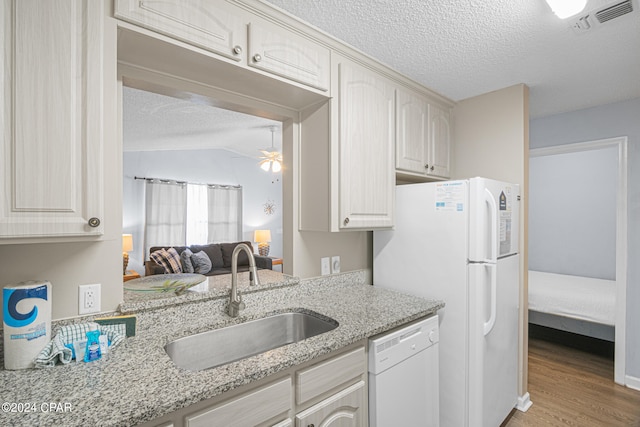 kitchen featuring white appliances, light hardwood / wood-style flooring, sink, light stone counters, and ceiling fan