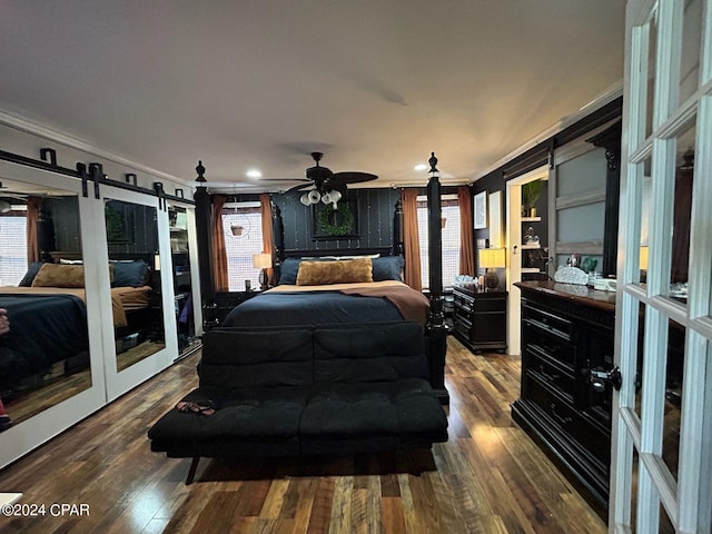 bedroom featuring dark hardwood / wood-style flooring, a barn door, and crown molding