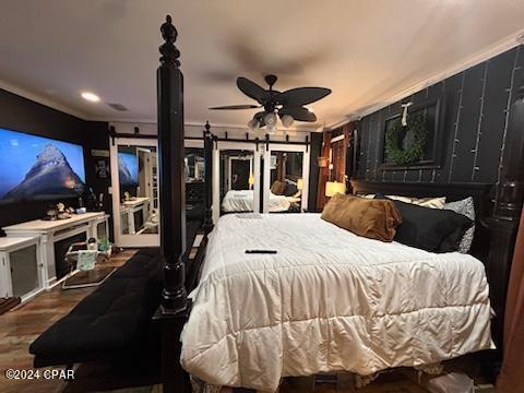 bedroom with crown molding, ceiling fan, and wood-type flooring