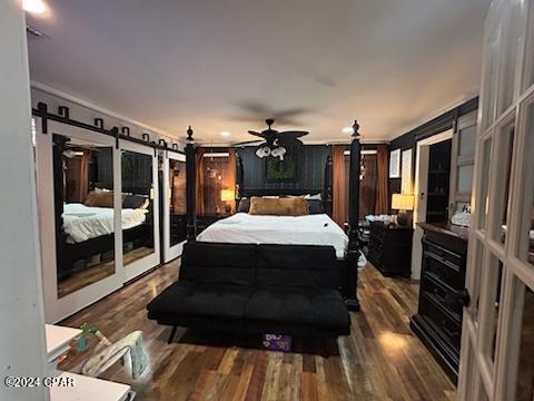 bedroom featuring a barn door, access to outside, ceiling fan, and dark hardwood / wood-style floors