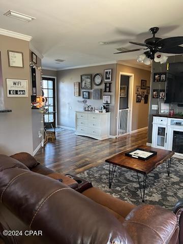 living room featuring ceiling fan, crown molding, and hardwood / wood-style flooring