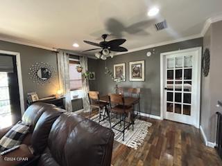 home theater room featuring ornamental molding, dark hardwood / wood-style flooring, and ceiling fan