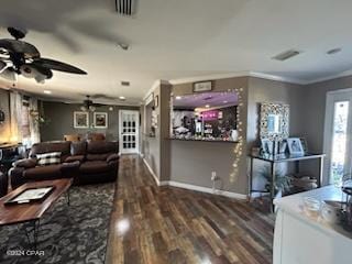 living room with ceiling fan, crown molding, and dark wood-type flooring