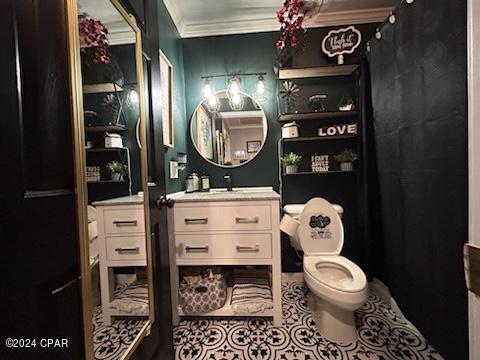 bathroom with vanity, crown molding, tile patterned flooring, and toilet