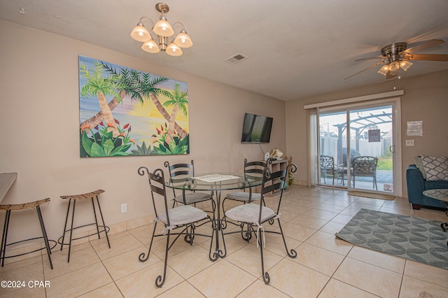 tiled dining area with ceiling fan with notable chandelier