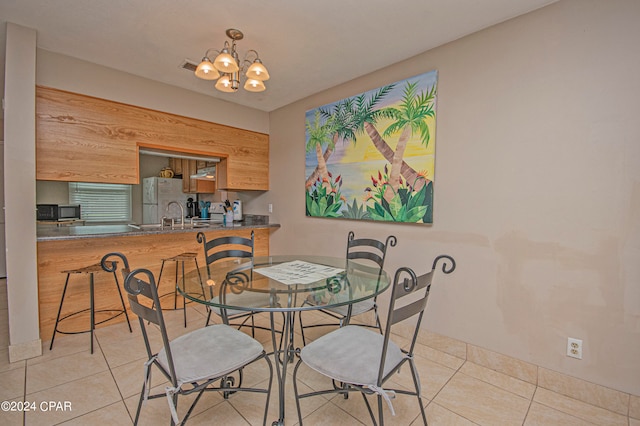 dining room with tile flooring, a notable chandelier, and sink