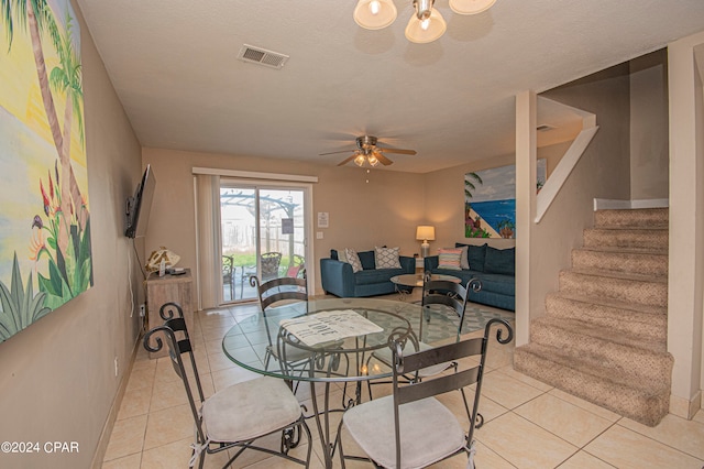 dining area with a textured ceiling, ceiling fan, and light tile floors