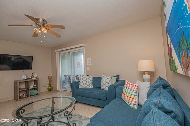 living room with a textured ceiling, ceiling fan, and light tile floors