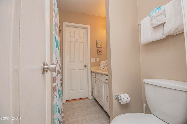 bathroom with toilet, tile floors, and vanity