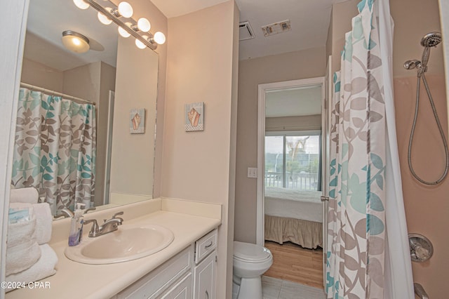 bathroom featuring toilet, vanity, and hardwood / wood-style floors