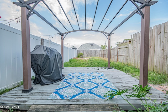 deck with a grill and a pergola