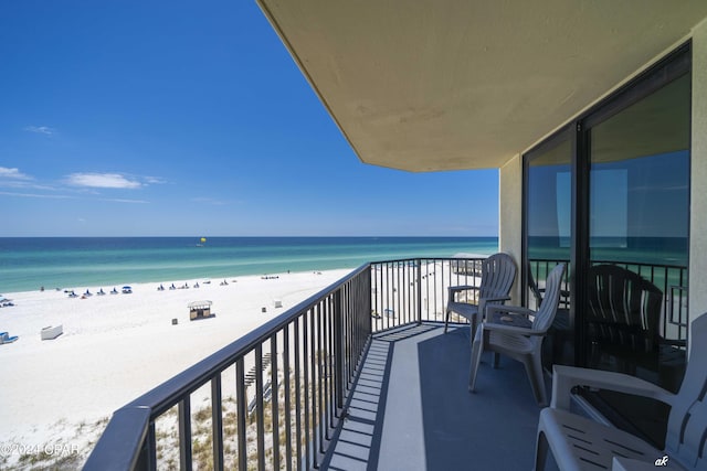 balcony featuring a view of the beach and a water view