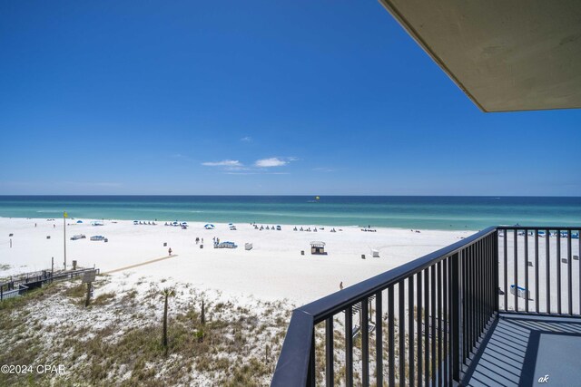 balcony featuring a view of the beach and a water view