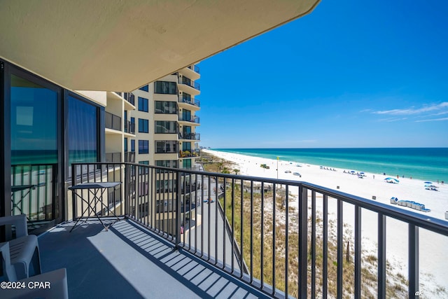 balcony with a water view and a view of the beach