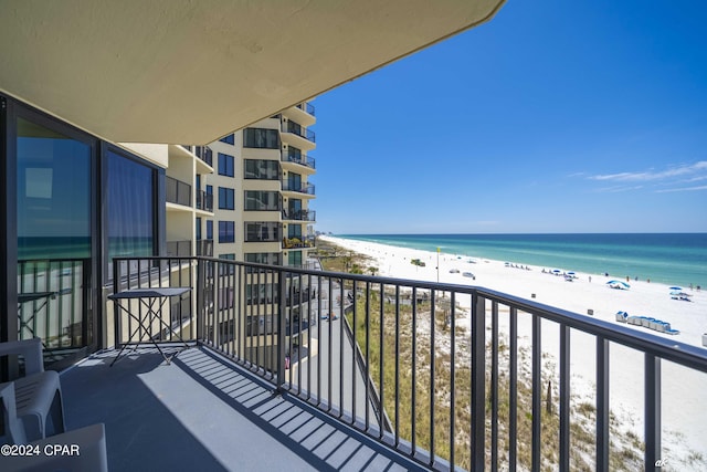 balcony with a water view and a beach view