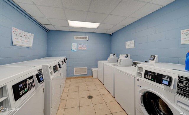 clothes washing area featuring light tile floors and separate washer and dryer