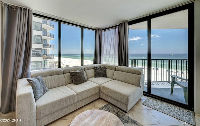 tiled living room featuring a wall of windows, a water view, and a view of the beach