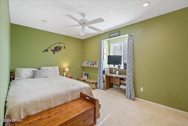 carpeted bedroom featuring ceiling fan and a textured ceiling