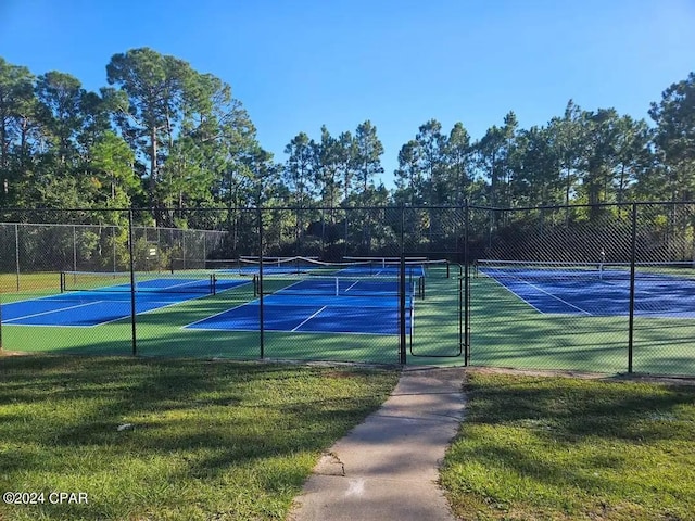 view of tennis court with a lawn