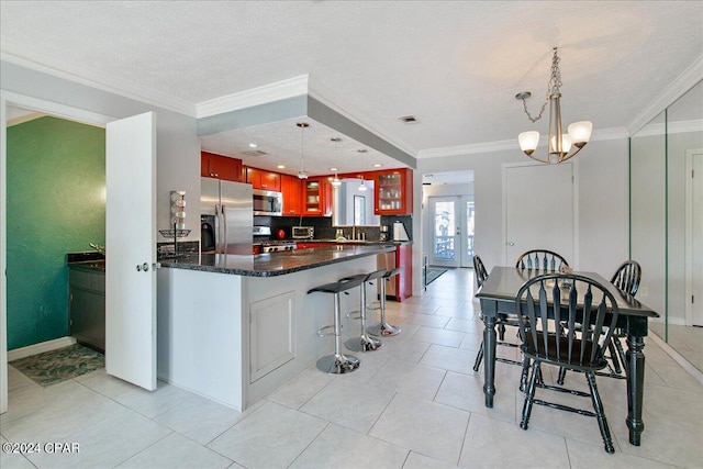 kitchen featuring a notable chandelier, hanging light fixtures, stainless steel appliances, and a textured ceiling