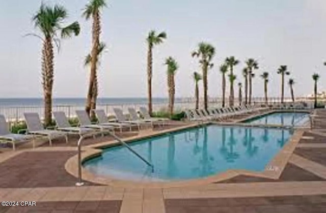 view of pool featuring a patio area and a water view