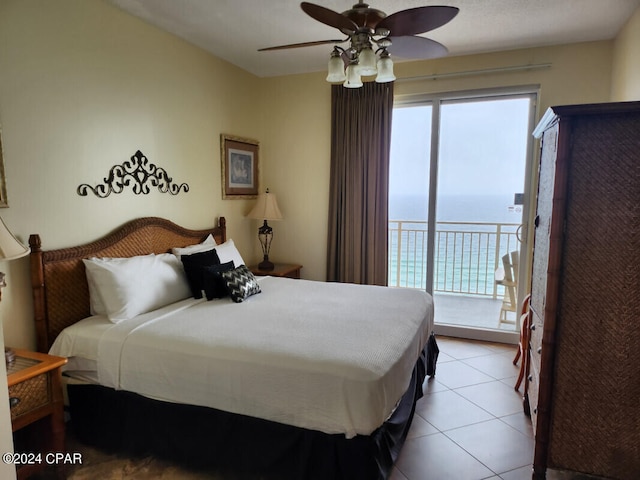 tiled bedroom with ceiling fan, access to exterior, and a water view