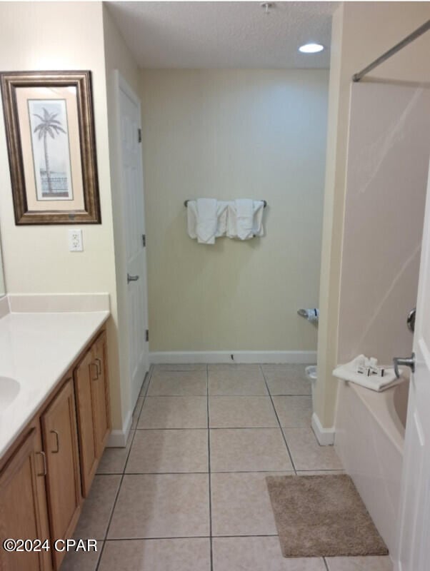 bathroom with a textured ceiling, vanity, and tile floors