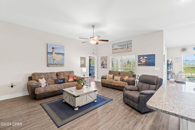 living room featuring light hardwood / wood-style flooring, a wealth of natural light, and ceiling fan