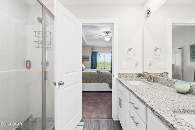 bathroom featuring walk in shower, hardwood / wood-style flooring, ceiling fan, and dual vanity