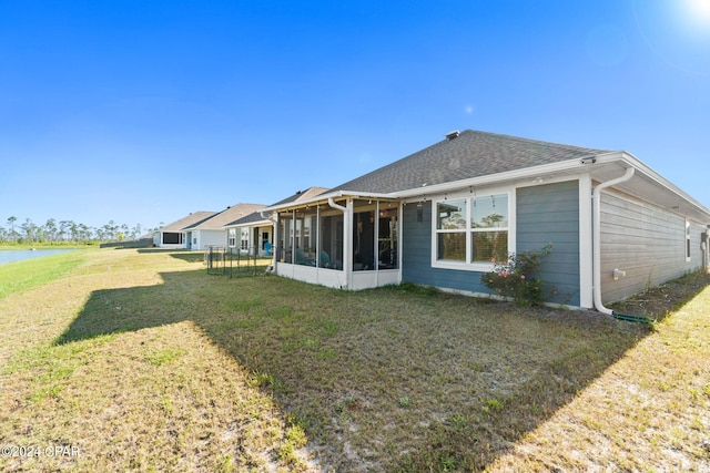 back of property with a lawn and a sunroom