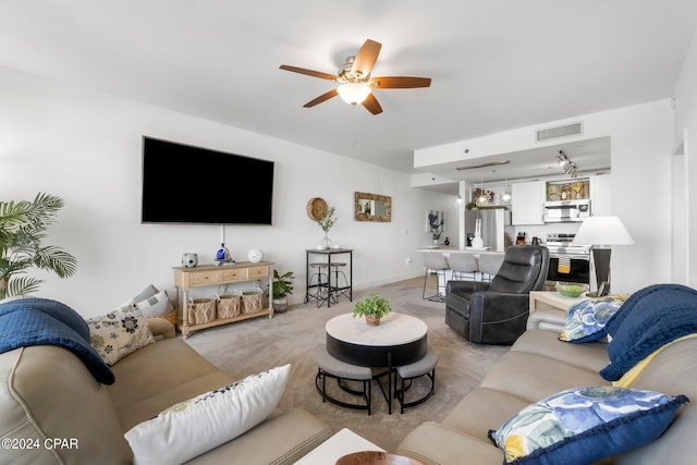 living area with ceiling fan, visible vents, and light colored carpet