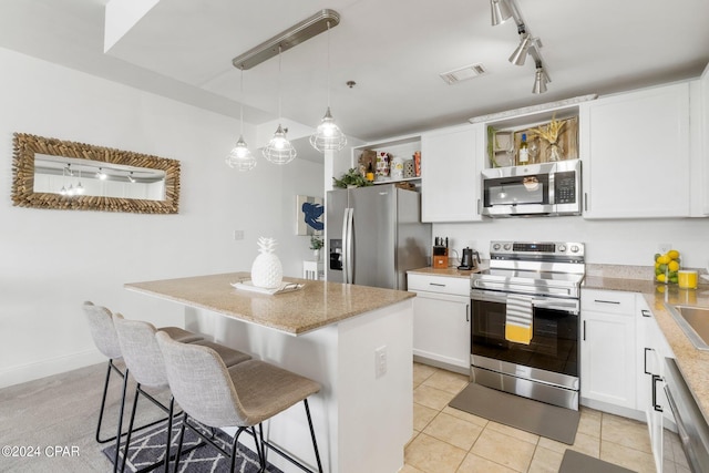 kitchen featuring visible vents, white cabinets, a center island, stainless steel appliances, and open shelves