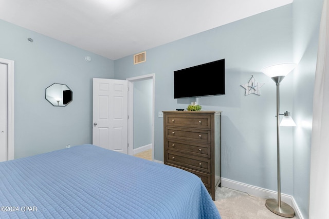 bedroom with baseboards, visible vents, and light colored carpet