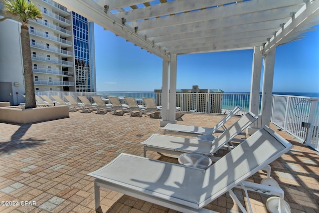 view of patio with a water view and a pergola