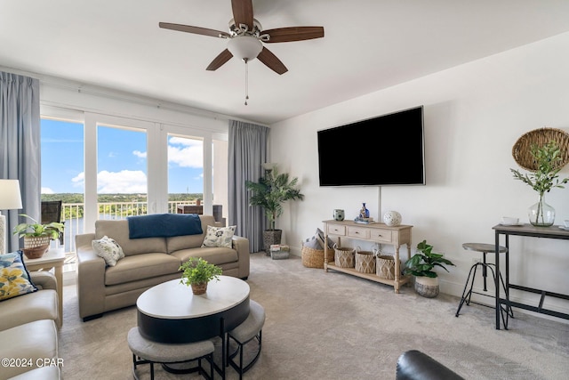 living room with ceiling fan, baseboards, and carpet flooring