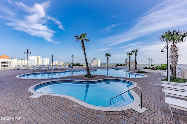 pool with a patio area and fence