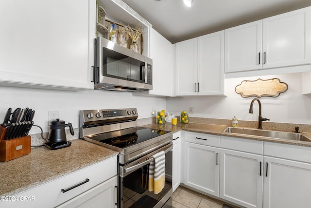 kitchen with stainless steel appliances, white cabinets, and a sink