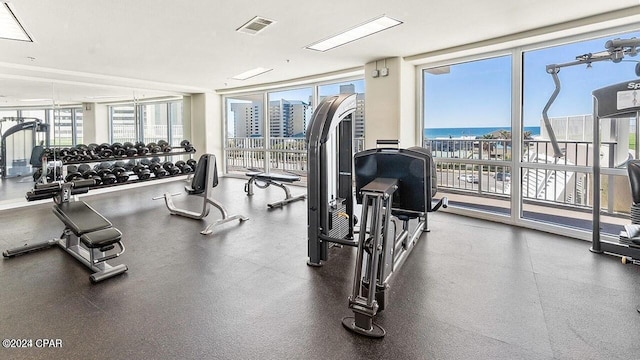 workout area featuring a wall of windows, visible vents, and a city view