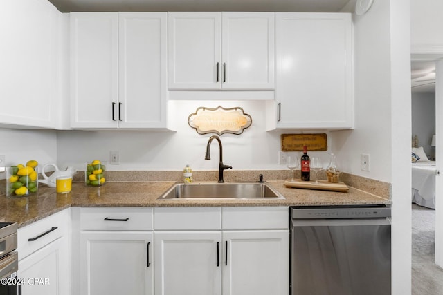 kitchen featuring a sink, white cabinetry, light stone counters, and dishwasher