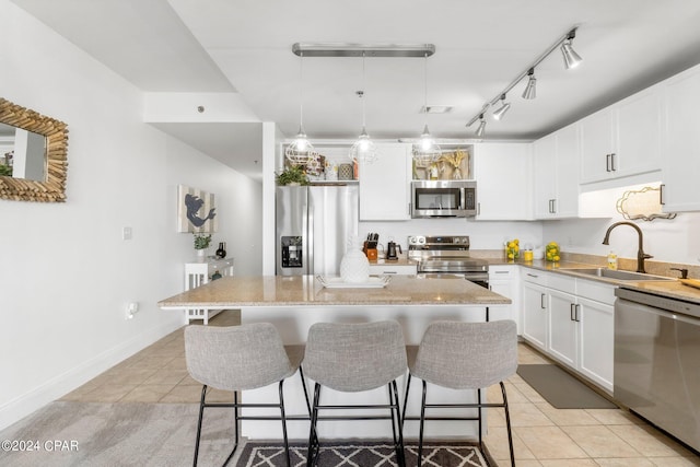 kitchen featuring a breakfast bar area, stainless steel appliances, light tile patterned flooring, a sink, and a kitchen island