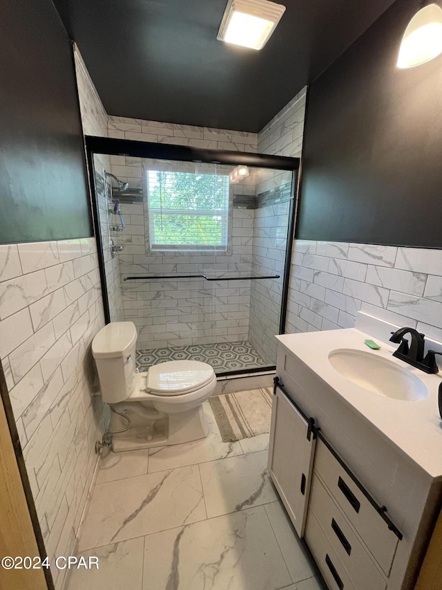 bathroom featuring toilet, tile walls, tile patterned floors, a shower with door, and vanity