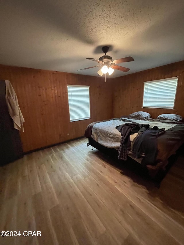 bedroom featuring ceiling fan, wood-type flooring, and a textured ceiling