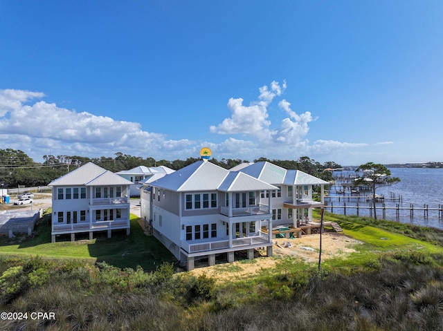 rear view of house featuring a water view and a yard