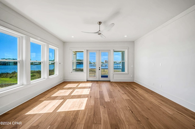 interior space featuring french doors, a water view, and ceiling fan